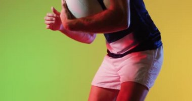 Sarı ışıkta oynayan rugby topu olan çeşitli erkek ragbi oyuncuları. Spor, hareket, eğitim ve aktif yaşam tarzı kavramı.