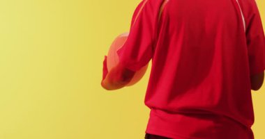 Afrika kökenli Amerikalı rugby oyuncusu ragbi topu ile neon sarısı ışığın üzerinde. Spor, hareket, eğitim ve aktif yaşam tarzı kavramı.