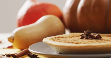 Video of autumn leaves, pumpkins, spices and pie on grey background. Halloween, autumn, tradition and celebration concept.
