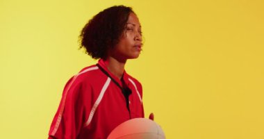 Neon sarısı ışıkta rugby topu taşıyan Afrika kökenli Amerikalı bayan rugby oyuncusu. Spor, hareket, eğitim ve aktif yaşam tarzı kavramı.