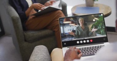African american man using laptop for video call, with business colleague on screen. Business communication technology and remote home working, digital composite video.