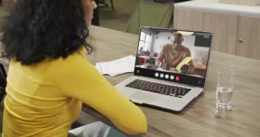 Biracial woman using laptop for video call, with business colleague on screen. Business communication technology and remote home working, digital composite video.