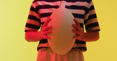 Kafkas kadın rugby oyuncusu, neon ışığın üzerinde rugby topu taşıyor. Spor, hareket, eğitim ve aktif yaşam tarzı kavramı.