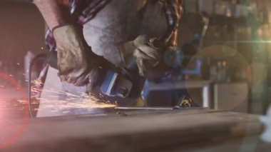 Atölyede öğütücü kullanan beyaz bir adamın üzerinde parlayan ışığın animasyonu. İşçi Bayramı, iş, işçiler, gelenek ve dijital olarak üretilen video konsepti.