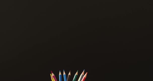 Video Stack Books Crayons Apple Black Background School Equipment Tools — стоковое видео