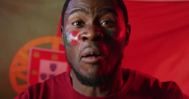 一个快乐的非洲裔美国男性足球支持者的画像 他的旗帜上挂着斑纹斑斑的粉红灯光 培训和积极生活方式概念 — 图库视频影像