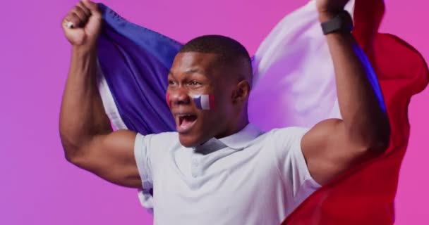 ピンクの照明の上にフランスの旗を持つ幸せなアフリカ系アメリカ人男性サッカーサポーター スポーツ トレーニング アクティブなライフスタイルの概念 — ストック動画