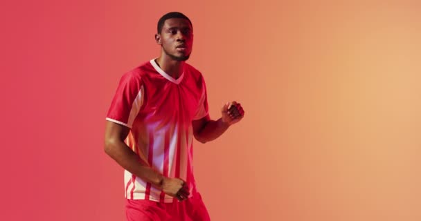 African American Male Soccer Player Kicking Football Neon Pink Lighting — Vídeos de Stock