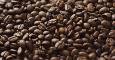 Video of close up of pile of close up roasted brown coffee beans. Coffee, refreshment and beverages.