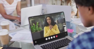 African american woman using laptop for video call, with business colleague on screen. Business communication technology and remote home working, digital composite video.