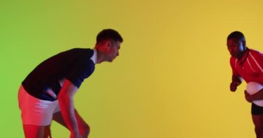 Sarı ışıkta oynayan rugby topu olan çeşitli erkek ragbi oyuncuları. Spor, hareket, eğitim ve aktif yaşam tarzı kavramı.