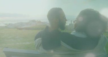 Sahildeki Afrikalı Amerikalı çiftin üzerindeki ışık noktalarının animasyonu. Boş zaman ve tatil kavramı dijital olarak oluşturulmuş video.