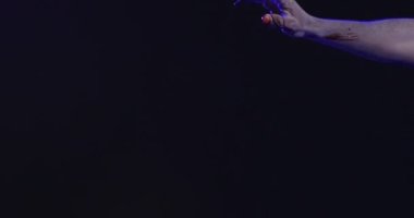 Video of hands covered with blood moving on black background. Halloween, autumn, tradition and celebration concept.