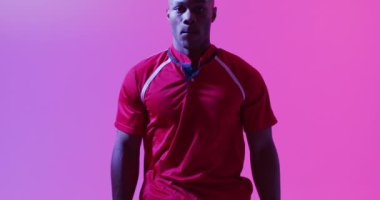 Pembe ışıkta Afrika kökenli Amerikalı erkek rugby oyuncusunun portresi. Spor, hareket, eğitim ve aktif yaşam tarzı kavramı.