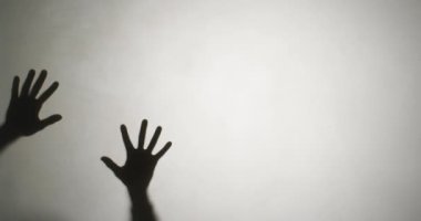 Video of silhouettes of hands moving on white background. Halloween, autumn, tradition and celebration concept.