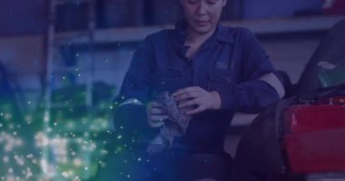 Atölyedeki beyaz kadın araba tamircisinin üzerinde parlayan ışıkların animasyonu. İşçi Bayramı, iş, işçiler, gelenek ve dijital olarak üretilen video konsepti.