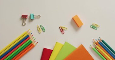 Video of composition of school items on white surface. School equipment, tools, learning and education concept.