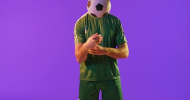 Kafkasyalı erkek futbolcu, neon pembe ışıkta futbol oynuyor. Spor, hareket, eğitim ve aktif yaşam tarzı kavramı.