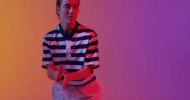 Beyaz kadın rugby oyuncusu neon pembe ışıkta rugby topu yakalıyor. Spor, hareket, eğitim ve aktif yaşam tarzı kavramı.