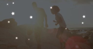 Sahildeki Afro-Amerikan çifti üzerinde yıldızların animasyonu. Boş zaman ve tatil kavramı dijital olarak oluşturulmuş video.