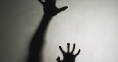 Video of silhouettes of hands moving on white background. Halloween, autumn, tradition and celebration concept.