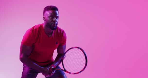 Odaklanmış Afrikalı Amerikalı Erkek Tenisçinin Neon Pembe Yıldırımla Topa Vuruşunun — Stok video