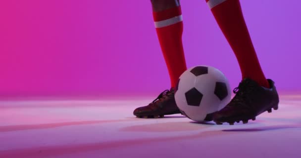 Afrikanischer Männlicher Fußballspieler Mit Fußball Über Neonrosa Beleuchtung Sport Bewegung — Stockvideo