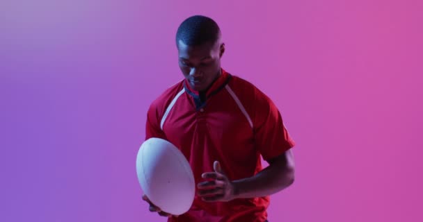 Retrato Jugador Rugby Afroamericano Con Pelota Rugby Sobre Iluminación Rosa — Vídeo de stock