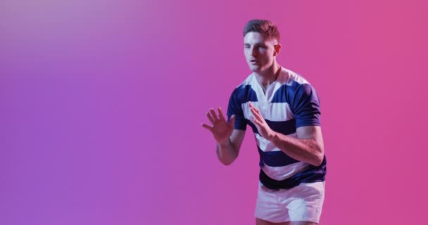 Caucasian Male Rugby Player Catching Rugby Ball Pink Lighting Sport — Stock Video