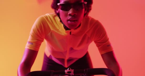 专注的非洲裔美国女骑手骑在霓虹橙色闪电上的视频 培训和积极生活方式概念 — 图库视频影像