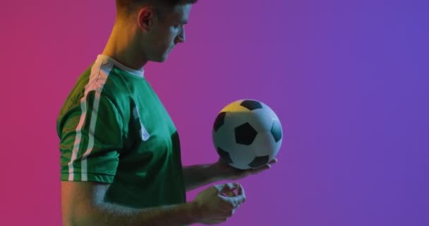 Kaukasischer Männlicher Fußballspieler Mit Fußball Über Neonrosa Beleuchtung Sport Bewegung — Stockvideo
