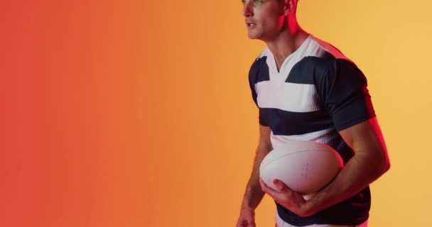 Heureux Joueur Rugby Masculin Caucasien Levant Main Sur Éclairage Orange — Video