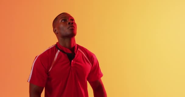 Afro Amerikaanse Mannelijke Rugbyspeler Vangt Rugbybal Oranje Verlichting Sport Beweging — Stockvideo