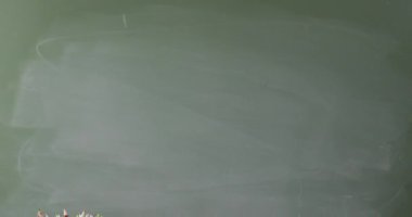 Video of books and cup with crayons on wooden table over mathematical formulas on blackboard. Education, learning and creativity