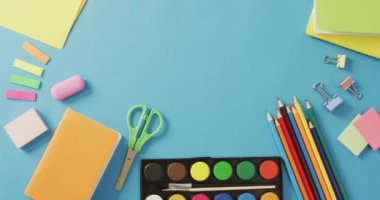 Video of frame with school equipment on blue surface. School equipment, tools, learning and education concept.