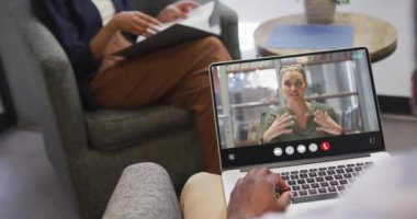 African american man using laptop for video call, with business colleague on screen. Business communication technology and remote home working, digital composite video.