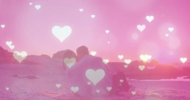 Sahildeki farklı çiftler üzerinde kalp ve ışık noktaları. Boş zaman ve tatil kavramı dijital olarak oluşturulmuş video.