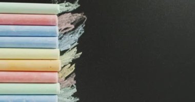 Video of composition with colorful pastels on back surface. School equipment, tools, learning and education concept.