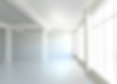 Defocused interior of empty corridor at white building