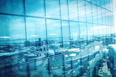 Cityscape reflecting on modern glass building