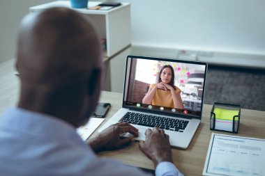 Bilgisayardaki video görüşmesi sırasında, Afrikalı Amerikalı iş adamı kadın meslektaşıyla beyin fırtınası yapıyor. değiştirilmemiş, ofis, çevrimiçi, teknoloji, video konferansı, tartışma, internet, iş, takım çalışması.
