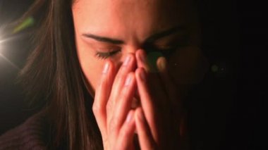 Stresli beyaz kadının siyah arka plandaki ışık lekesi karşısında yakın plan görüntüsü. zihinsel sağlık günü farkındalığı kavramı