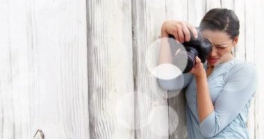 Beyaz noktalar beyaz kadın fotoğrafçıya karşı yüzüyor. Dijital fotoğraf makinesinde resimlerini kontrol ediyor. dünya fotoğraf günü farkındalık kavramı