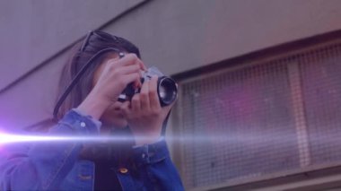 Beyaz kadın fotoğrafçıya karşı bir ışık lekesi dışarıda dijital kamerayla fotoğraf çekiyor. dünya fotoğraf günü farkındalık kavramı