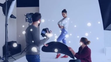 Beyaz noktalar beyaz erkek fotoğrafçıya karşı yüzüyor. Stüdyoda kadın modelin resimlerini çekiyor. dünya fotoğraf günü farkındalık kavramı