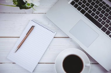 Directly above shot of laptop with book and coffee cup on table