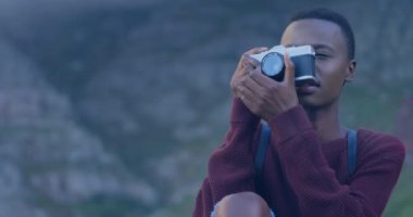 Afrikalı Amerikalı kadın fotoğrafçıya karşı bir ışık lekesi dijital kamerayla fotoğraf çekiyor. dünya fotoğraf günü farkındalık kavramı