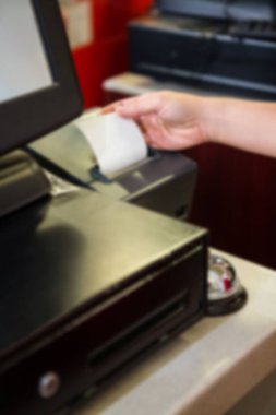 Cropped image of person holding receipt generated from cash register