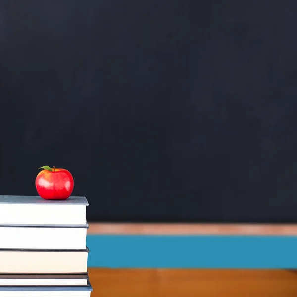 教室で本の山の上の赤いりんご — ストック写真