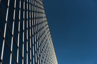 Low angle view of office building against blue sky